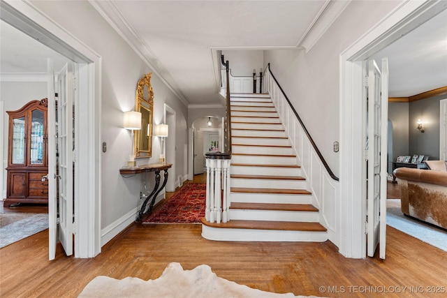 319 E 21st St, Tulsa, OK 74114 - stairs featuring wood finished floors, crown molding, and arched walkways