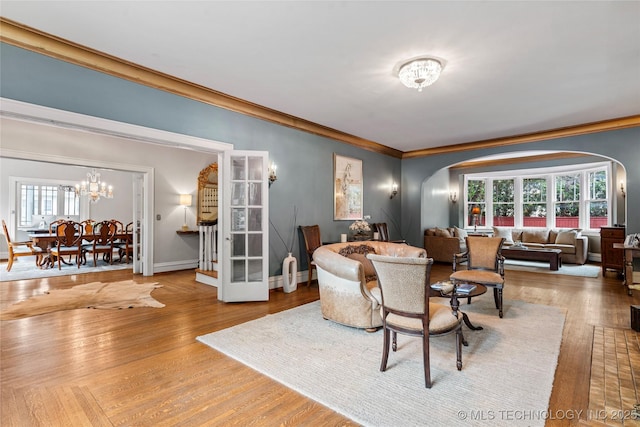 319 E 21st St, Tulsa, OK 74114 - living area with arched walkways, a chandelier, crown molding, wood finished floors, and baseboards