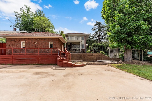 319 E 21st St, Tulsa, OK 74114 - view of front facade with brick siding, a tiled roof, and a patio