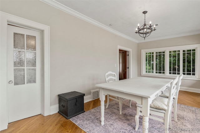 319 E 21st St, Tulsa, OK 74114 - dining space featuring a chandelier, wood finished floors, and ornamental molding