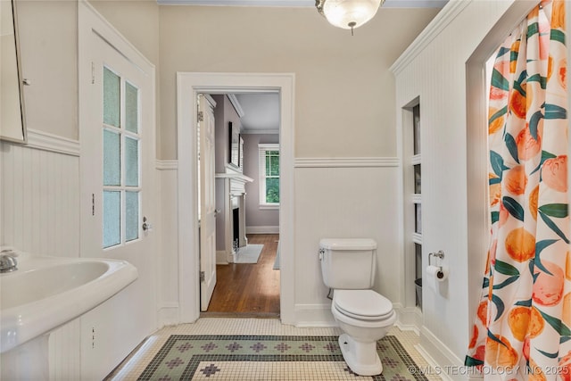 319 E 21st St, Tulsa, OK 74114 - full bath with curtained shower, a fireplace with flush hearth, tile patterned floors, and a wainscoted wall