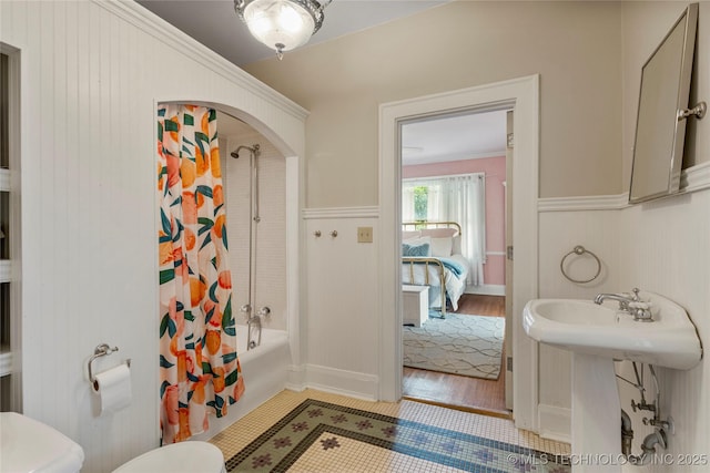 319 E 21st St, Tulsa, OK 74114 - ensuite bathroom with shower / bath combination with curtain, a wainscoted wall, and tile patterned floors