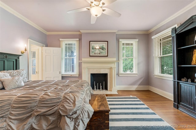 319 E 21st St, Tulsa, OK 74114 - bedroom featuring wood finished floors, baseboards, crown molding, a premium fireplace, and a ceiling fan