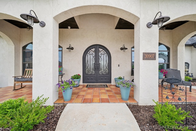 30907 E 68th St S, Broken Arrow, OK 74014 - view of exterior entry with a porch and stucco siding