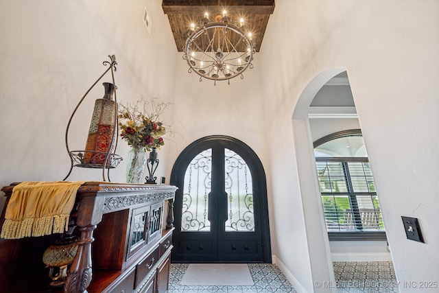 30907 E 68th St S, Broken Arrow, OK 74014 - foyer featuring arched walkways, french doors, a chandelier, baseboards, and a towering ceiling