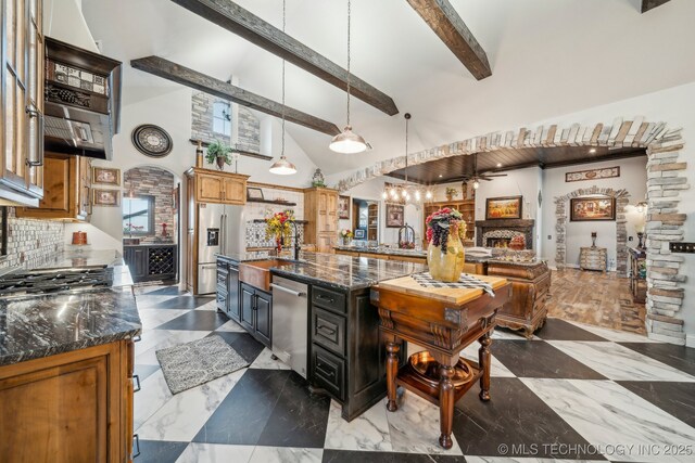 30907 E 68th St S, Broken Arrow, OK 74014 - kitchen featuring a sink, stainless steel appliances, beamed ceiling, high vaulted ceiling, and dark stone counters