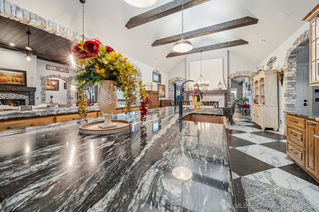 30907 E 68th St S, Broken Arrow, OK 74014 - kitchen featuring a lit fireplace, beam ceiling, a sink, hanging light fixtures, and a chandelier