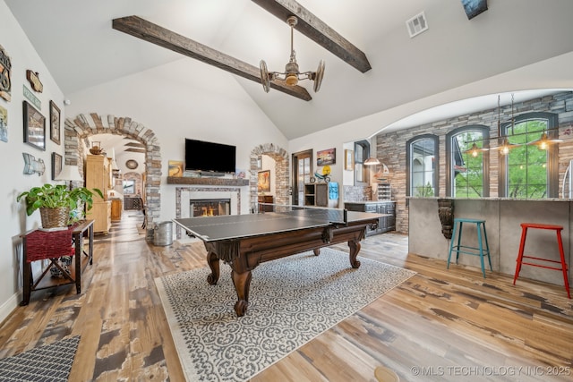 30907 E 68th St S, Broken Arrow, OK 74014 - rec room featuring a warm lit fireplace, arched walkways, high vaulted ceiling, beamed ceiling, and a chandelier