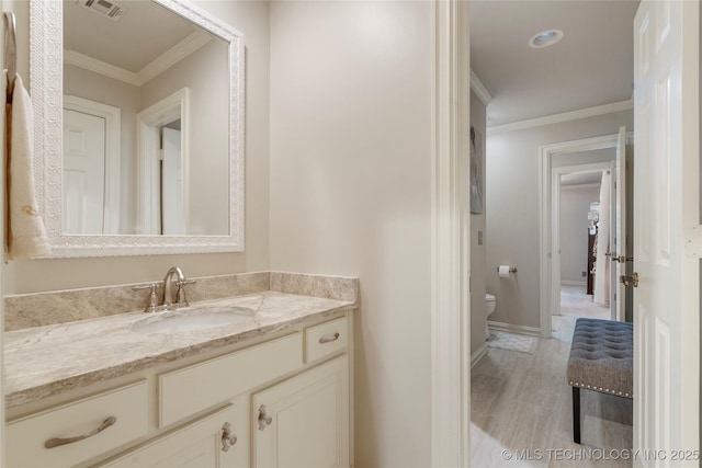 11406 69th E Pl, Bixby, OK 74008 - bathroom with toilet, vanity, crown molding, and baseboards