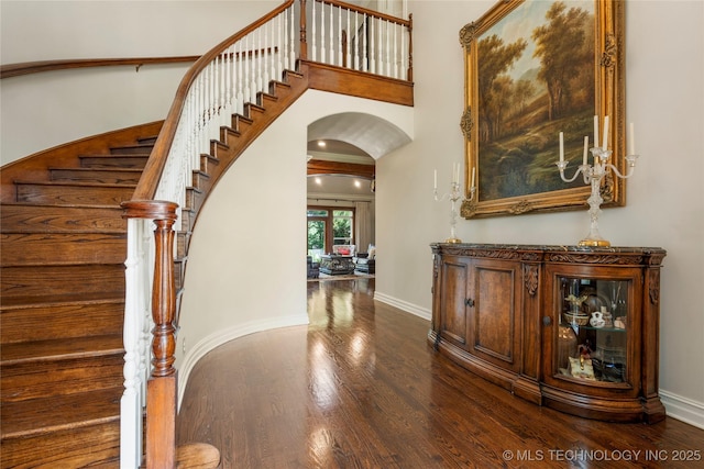11406 69th E Pl, Bixby, OK 74008 - foyer entrance featuring arched walkways, dark wood-style floors, stairway, baseboards, and a high ceiling