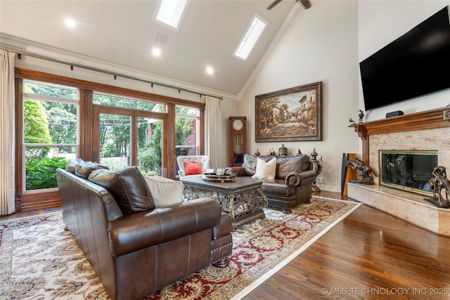 11406 69th E Pl, Bixby, OK 74008 - living room featuring high vaulted ceiling, wood finished floors, a premium fireplace, a skylight, and recessed lighting