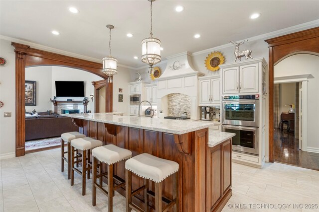 11406 69th E Pl, Bixby, OK 74008 - kitchen featuring stainless steel appliances, light stone counters, crown molding, open floor plan, and recessed lighting