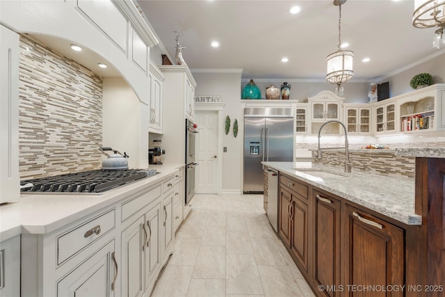 11406 69th E Pl, Bixby, OK 74008 - kitchen with stainless steel appliances, a sink, backsplash, crown molding, and glass insert cabinets