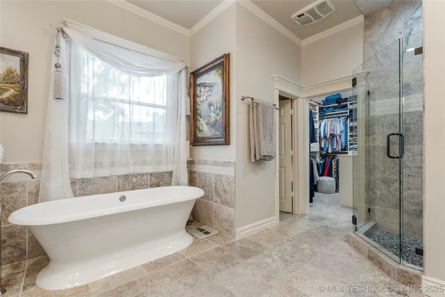 11406 69th E Pl, Bixby, OK 74008 - bathroom with tile walls, a freestanding bath, a shower stall, crown molding, and a spacious closet