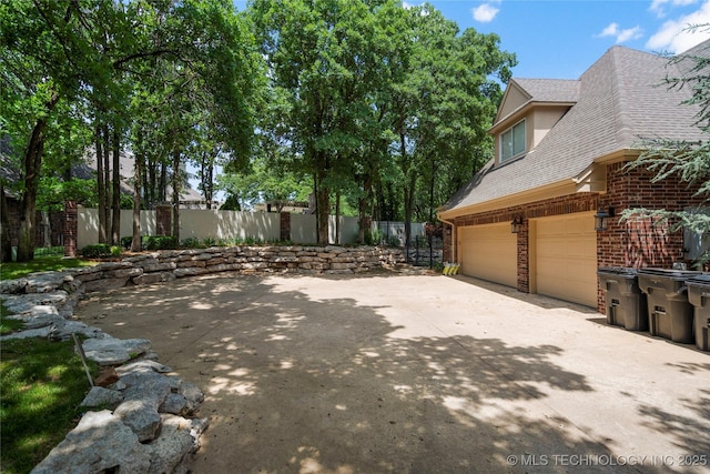11406 69th E Pl, Bixby, OK 74008 - view of side of property featuring brick siding, a garage, roof with shingles, and concrete driveway