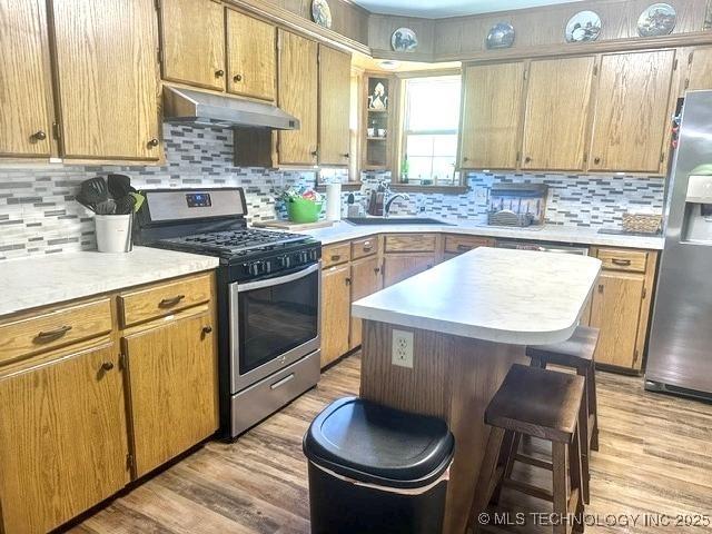 3293 W Southern Ave, Hulbert, OK 74441 - kitchen with appliances with stainless steel finishes, under cabinet range hood, a sink, and decorative backsplash
