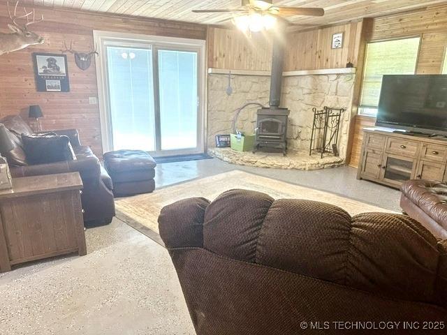 3293 W Southern Ave, Hulbert, OK 74441 - living area featuring a wood stove, wood walls, and ceiling fan