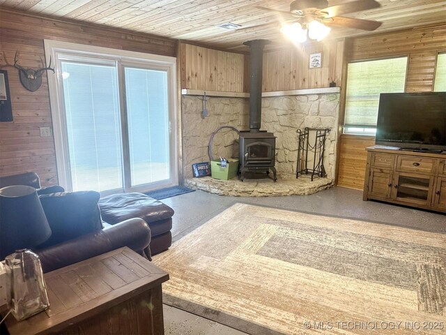 3293 W Southern Ave, Hulbert, OK 74441 - living area featuring a wood stove, healthy amount of natural light, wooden walls, a ceiling fan, and wood ceiling