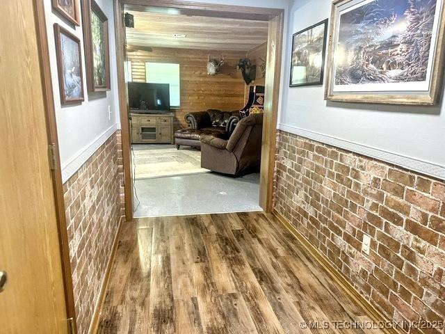 3293 W Southern Ave, Hulbert, OK 74441 - corridor featuring wood finished floors, wooden walls, wainscoting, and brick wall