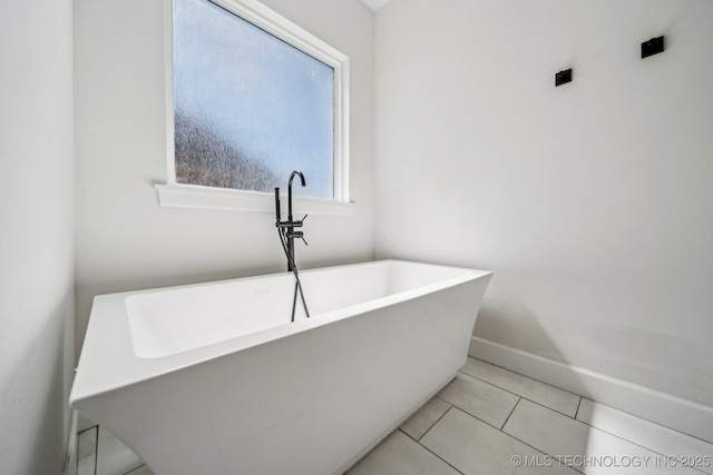123 E 168th St, Glenpool, OK 74033 - full bath with a soaking tub, baseboards, and tile patterned flooring