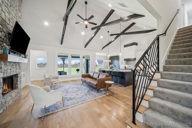 123 E 168th St, Glenpool, OK 74033 - living area with high vaulted ceiling, a stone fireplace, stairway, light wood-style floors, and ceiling fan