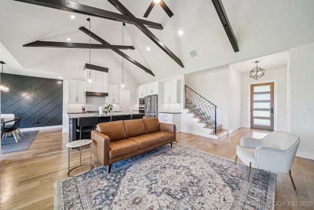 123 S 168th St, Glenpool, OK 74033 - living room featuring a chandelier, beam ceiling, stairs, high vaulted ceiling, and light wood-style floors