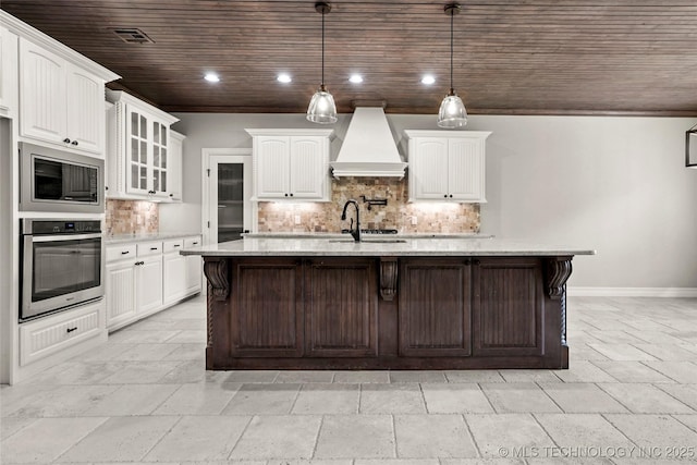 2236 W Charlotte St, Broken Arrow, OK 74011 - kitchen featuring appliances with stainless steel finishes, custom range hood, wooden ceiling, stone tile floors, and white cabinetry