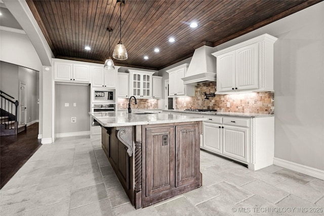2236 W Charlotte St, Broken Arrow, OK 74011 - kitchen featuring custom range hood, stainless steel appliances, a sink, wooden ceiling, and baseboards