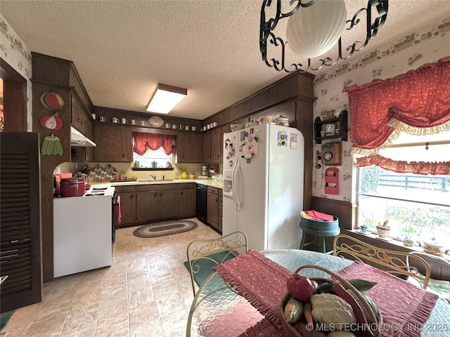 7122 S Shelby Ln, Broken Arrow, OK 74014 - kitchen featuring white appliances, light countertops, dark brown cabinets, under cabinet range hood, and wallpapered walls
