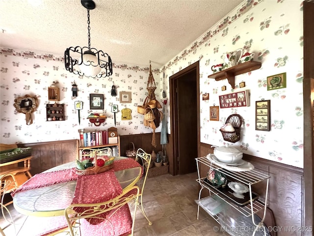 7122 S Shelby Ln, Broken Arrow, OK 74014 - dining room with wallpapered walls, a textured ceiling, wainscoting, and a chandelier