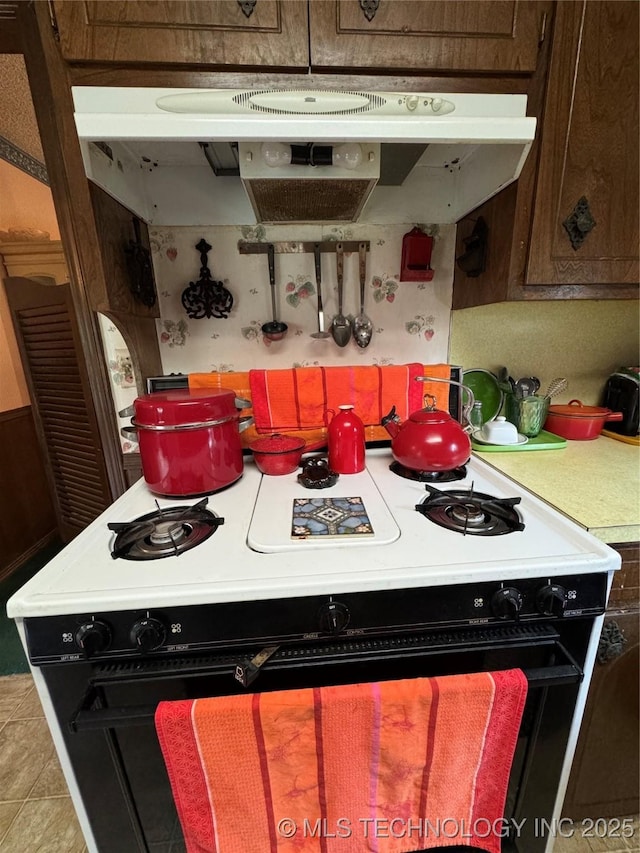 7122 S Shelby Ln, Broken Arrow, OK 74014 - kitchen with gas stove, under cabinet range hood, and light countertops