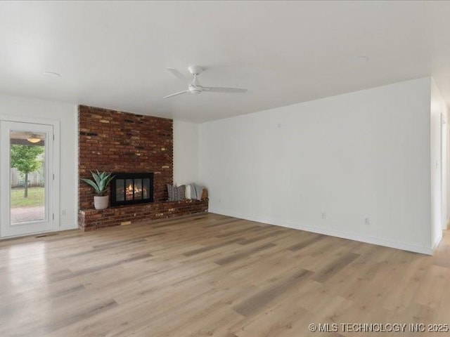 817 N Ivy St, Jenks, OK 74037 - unfurnished living room featuring light wood-style floors, ceiling fan, a brick fireplace, and baseboards