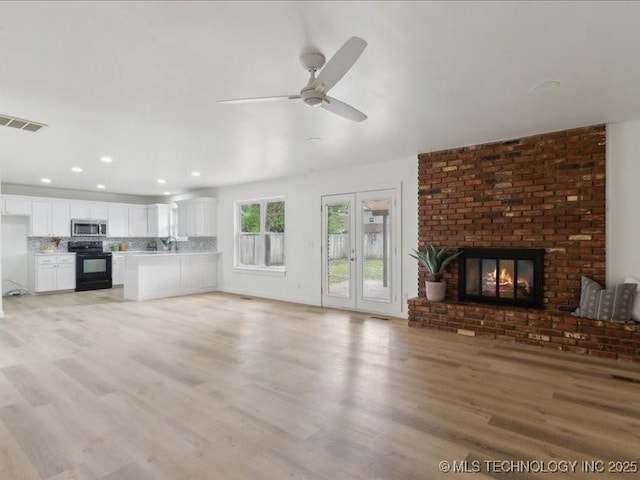 817 N Ivy St, Jenks, OK 74037 - unfurnished living room featuring light wood-style flooring, a ceiling fan, a fireplace, and recessed lighting