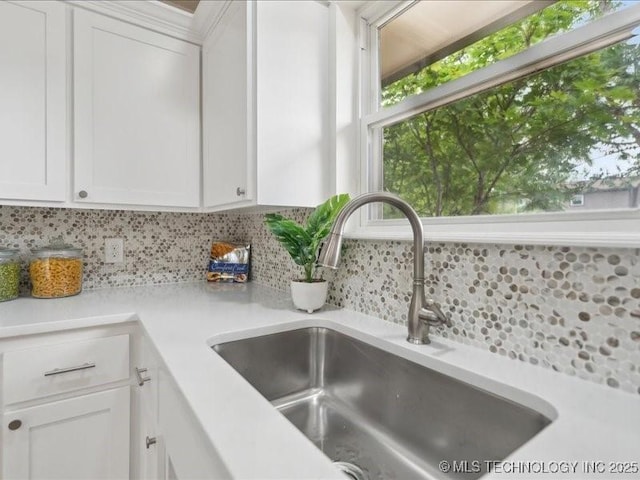 817 N Ivy St, Jenks, OK 74037 - kitchen view of a sink, decorative backsplash, light countertops, and white cabinetry