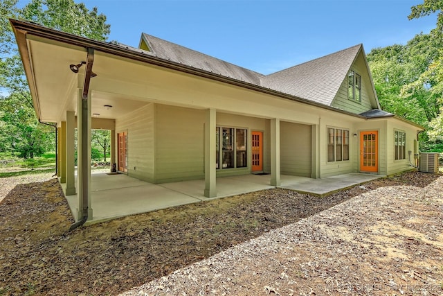 900 W Hardesty Rd, Caddo, OK 74729 - rear view of house with cooling unit, a shingled roof, and a patio area