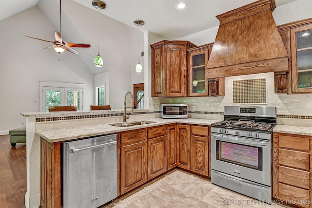 900 W Hardesty Rd, Caddo, OK 74729 - kitchen with appliances with stainless steel finishes, a sink, a peninsula, brown cabinets, and a ceiling fan