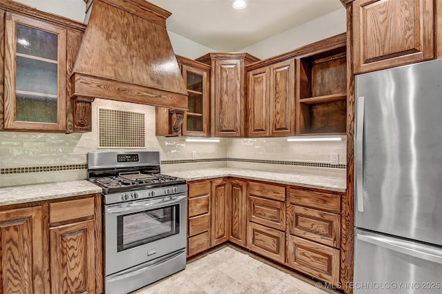 900 W Hardesty Rd, Caddo, OK 74729 - kitchen with stainless steel appliances, custom range hood, open shelves, tasteful backsplash, and light stone countertops