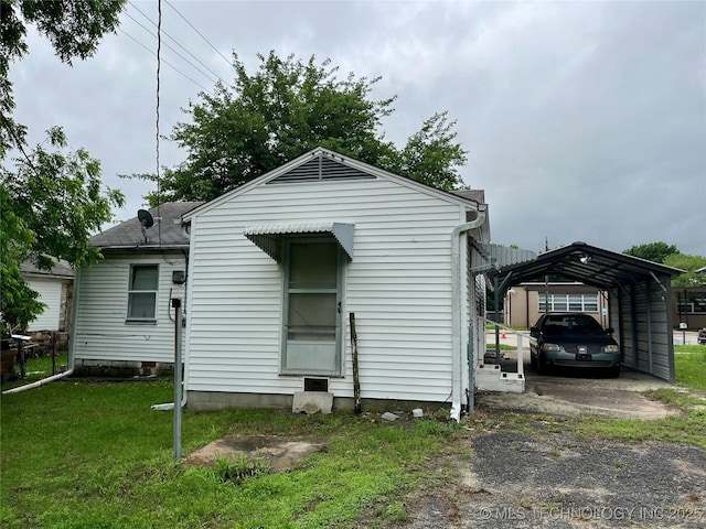 804 W 10th, Ada, OK 74820 - rear view of property featuring a detached carport and a lawn