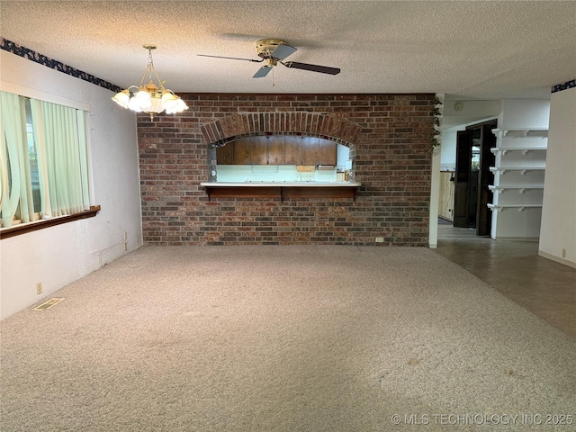 2099 S 80th St E, Muskogee, OK 74403 - unfurnished living room with a textured ceiling, ceiling fan, and brick wall