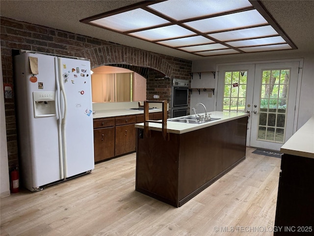 2099 S 80th St E, Muskogee, OK 74403 - kitchen with white appliances, a sink, light wood-type flooring, and light countertops