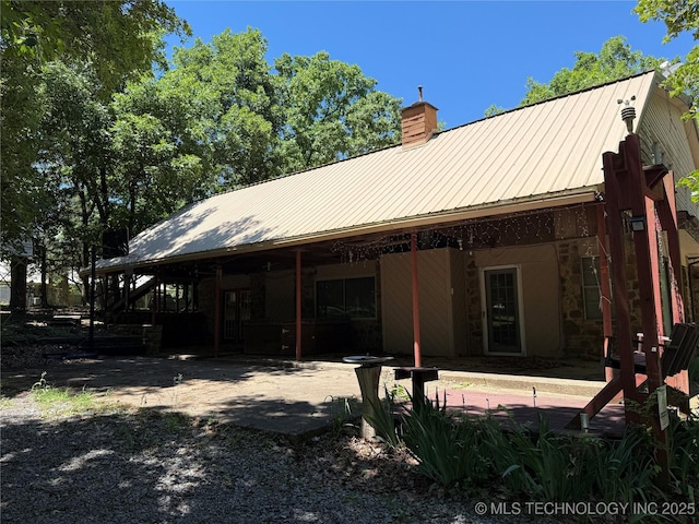 2099 S 80th St E, Muskogee, OK 74403 - rear view of property with a chimney, a patio, metal roof, and stone siding