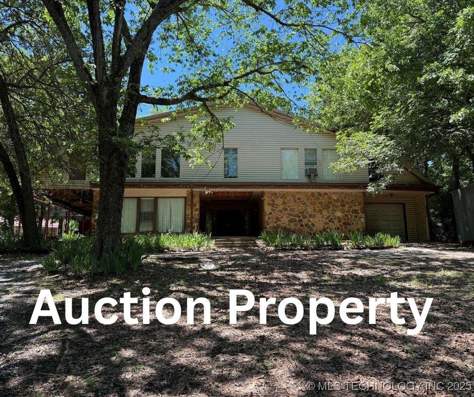 2099 S 80th St E, Muskogee, OK 74403 - view of front of property with stone siding and a garage