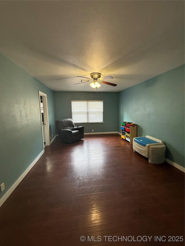 1732 N Little, Cushing, OK 74023 - sitting room with wood finished floors, baseboards, a ceiling fan, and a textured ceiling