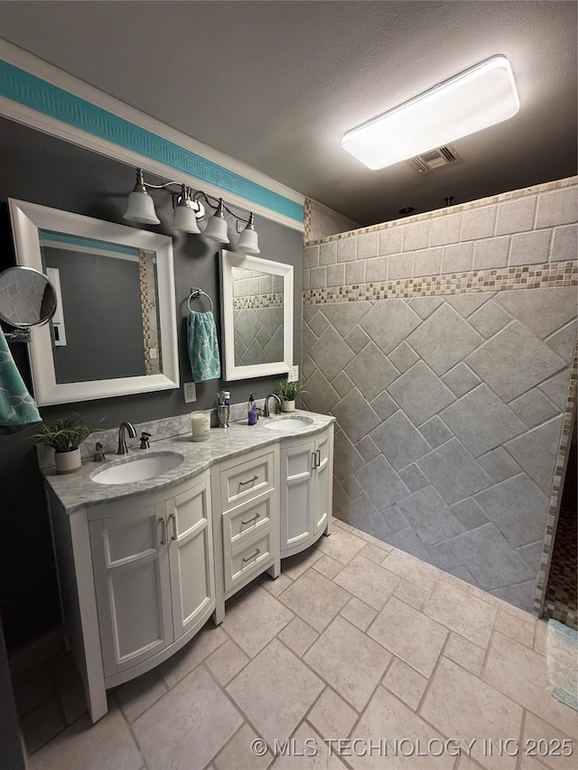 1732 N Little, Cushing, OK 74023 - bathroom featuring double vanity, tile walls, a textured ceiling, and tiled shower
