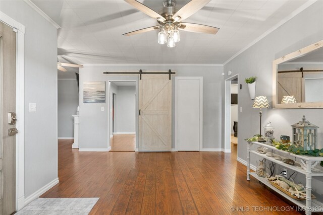 1732 N Little, Cushing, OK 74023 - entryway featuring a barn door, ceiling fan, wood-type flooring, and crown molding
