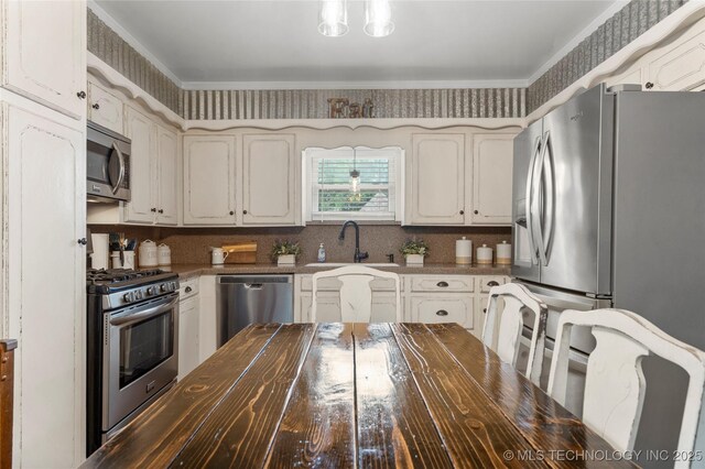 1732 N Little, Cushing, OK 74023 - kitchen featuring appliances with stainless steel finishes, butcher block countertops, backsplash, white cabinets, and crown molding