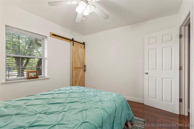 1732 N Little, Cushing, OK 74023 - bedroom with a barn door, wood finished floors, and ceiling fan