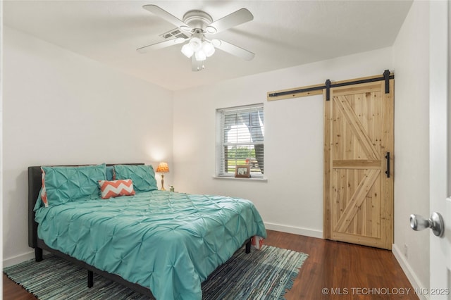 1732 N Little, Cushing, OK 74023 - bedroom with a barn door, wood finished floors, and a ceiling fan