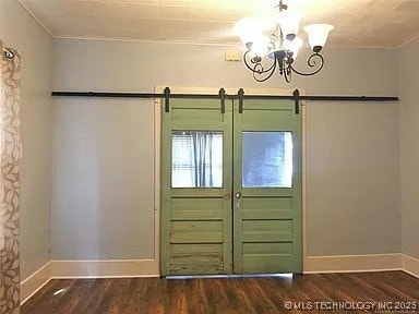 403 W Broadway, Marietta, OK 73448 - foyer featuring wood finished floors, baseboards, a chandelier, ornamental molding, and a barn door