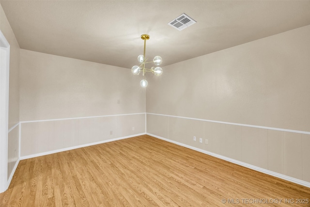 9429 E 36th St, Tulsa, OK 74145 - spare room featuring wood finished floors, a chandelier, and baseboards